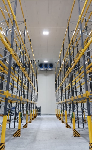 Un grand entrepôt blanc avec des structures de stockage en métal